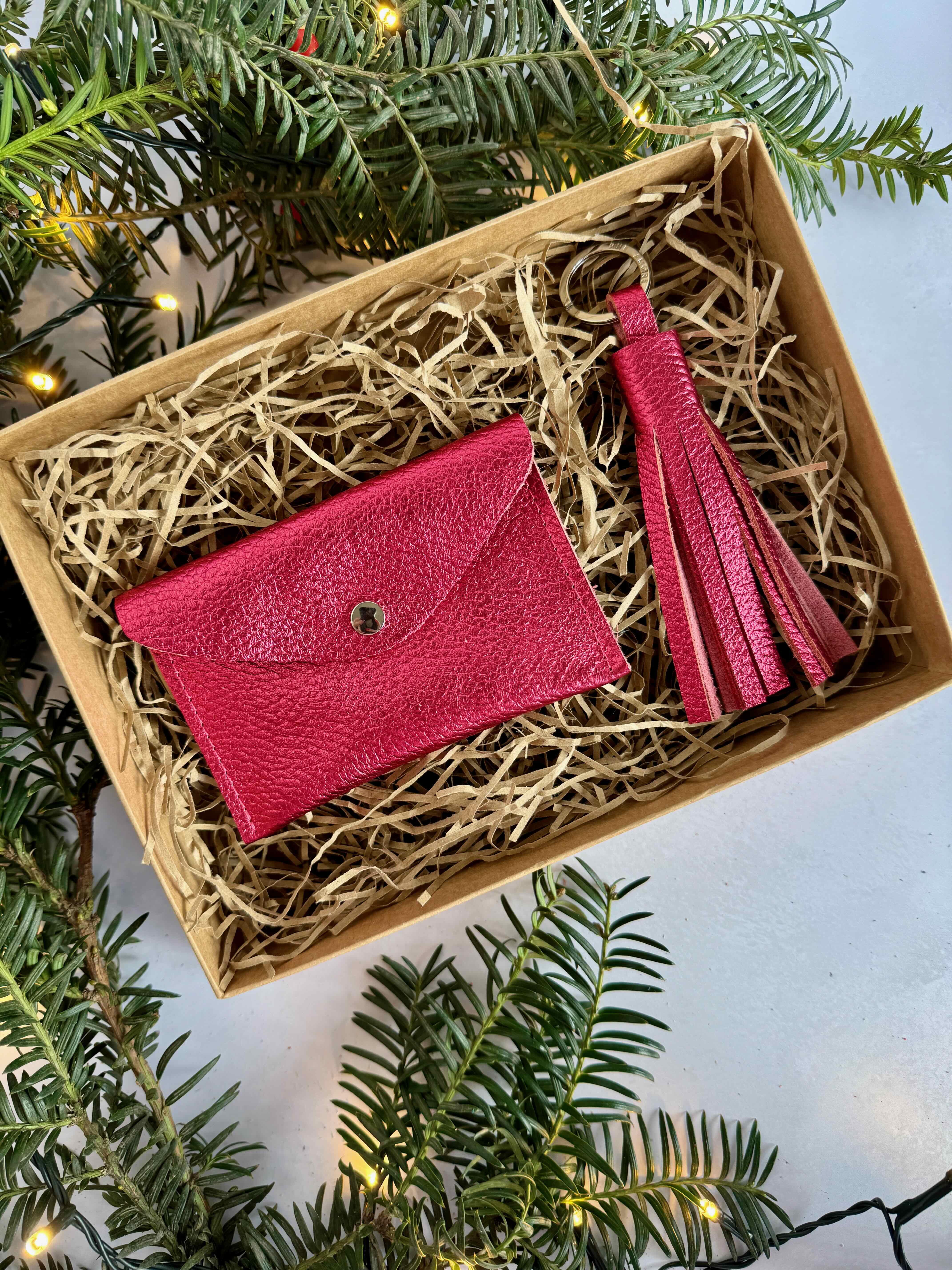 pink metallic wallet and tassel in a box with Christmas decorations