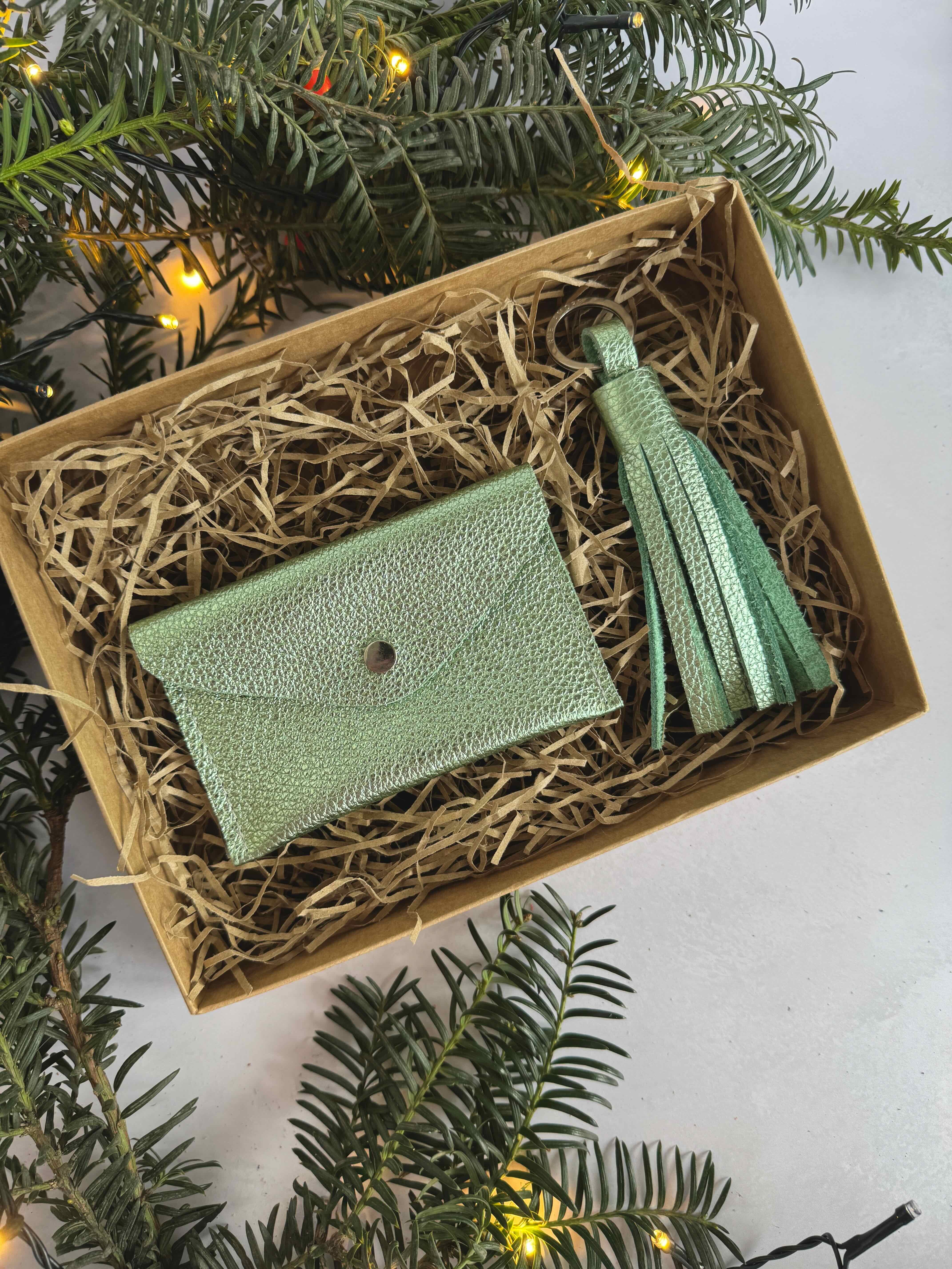 metallic Green leather wallet and tassel in a box with Christmas decorations
